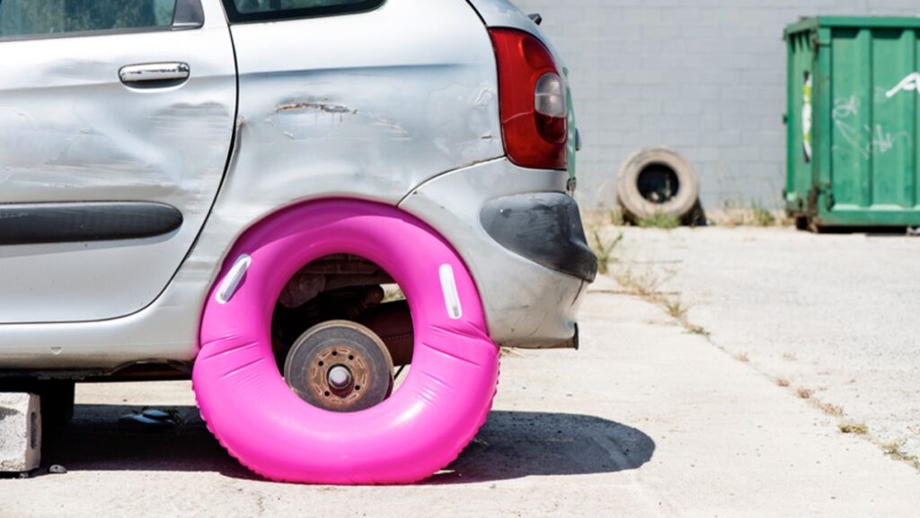 Car with punctured rear tire.