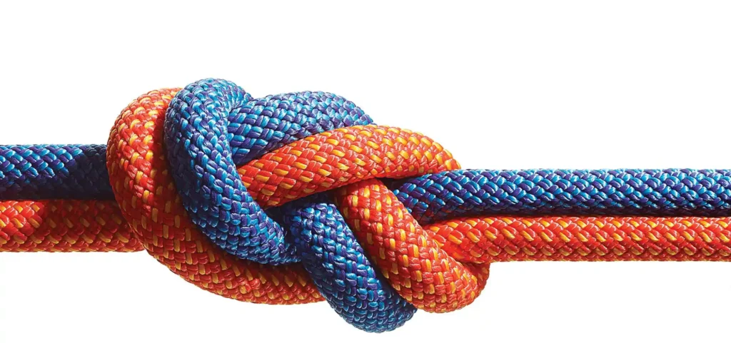 A knot done by using two different ropes, one red and one blue. The knot conveys trust and reliability which in turn relates to inbound marketing.