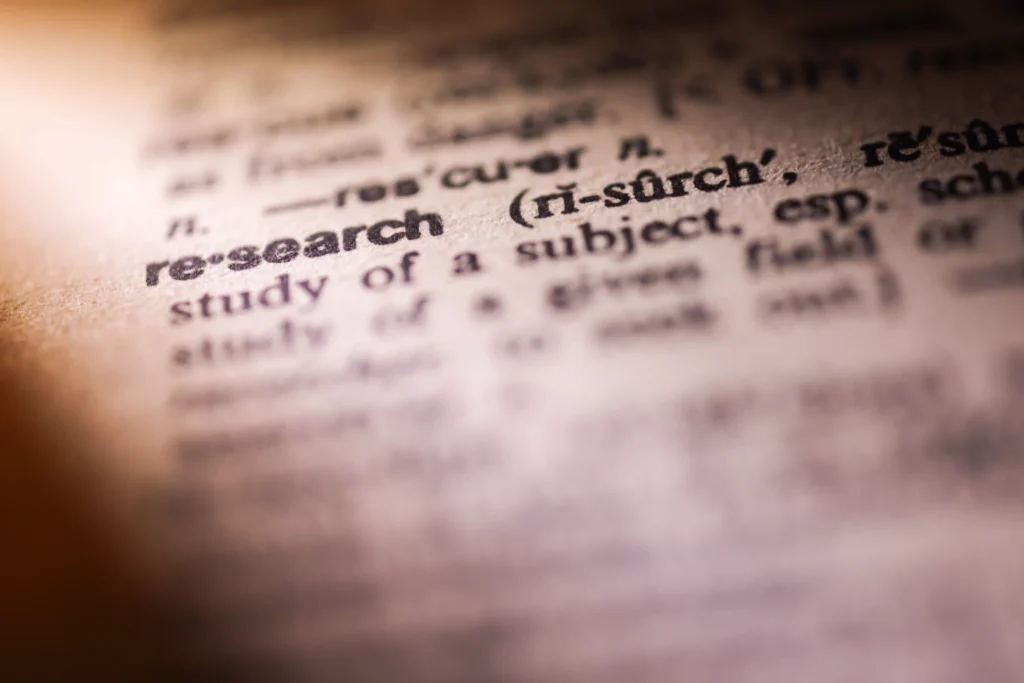Close-up of a dictionary page highlighting the word "research," symbolizing the importance of keyword research in SEO strategy.