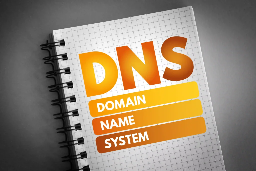 Notebook with bold DNS Domain Name System text, illustrating how domain infrastructure supports website accessibility, stability, and SEO performance.