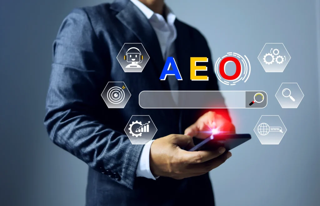 Business professional using a smartphone with “AEO” and AI icons, representing answer engine optimisation and AI-driven search in 2026.